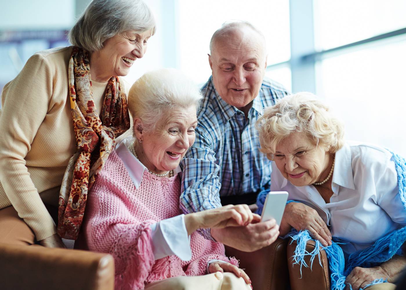 Starsze osoby sprawdzają informacje w internecie na telefonie