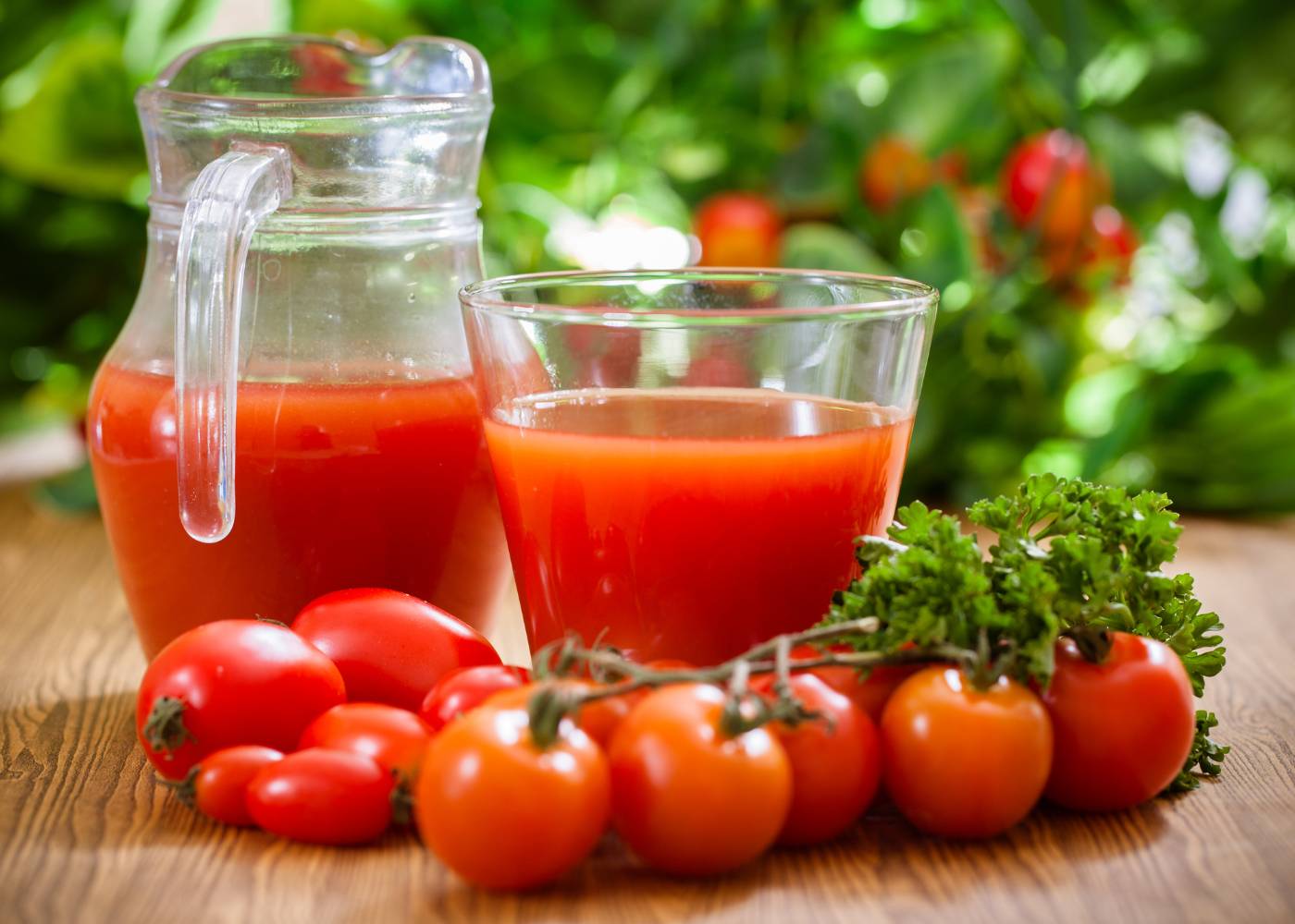 Sok pomidorowy i dna moczanowa. Na zdjęciu pomidory i sok pomidorowy w szklanym dzbanku